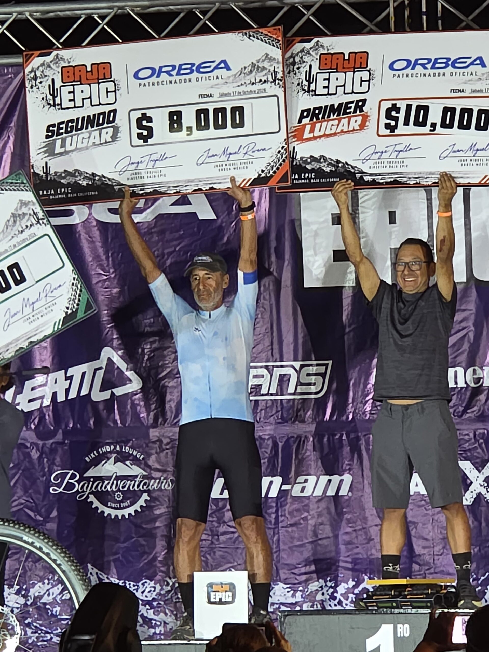 Coached athlete Miguel holding his prize check for 2nd place overall at the 2026 Baja Epic